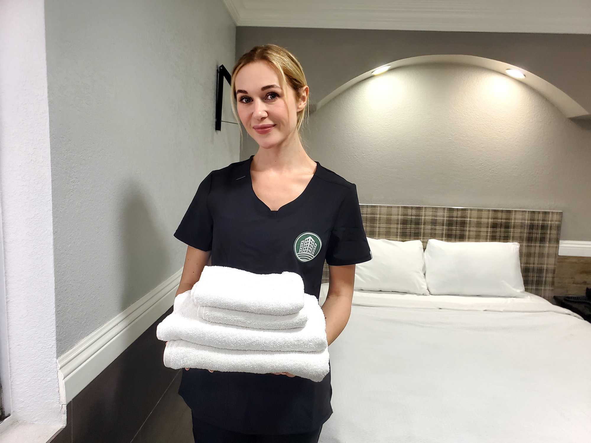 AmeriCorp housekeeper with fresh folded hotel linens
